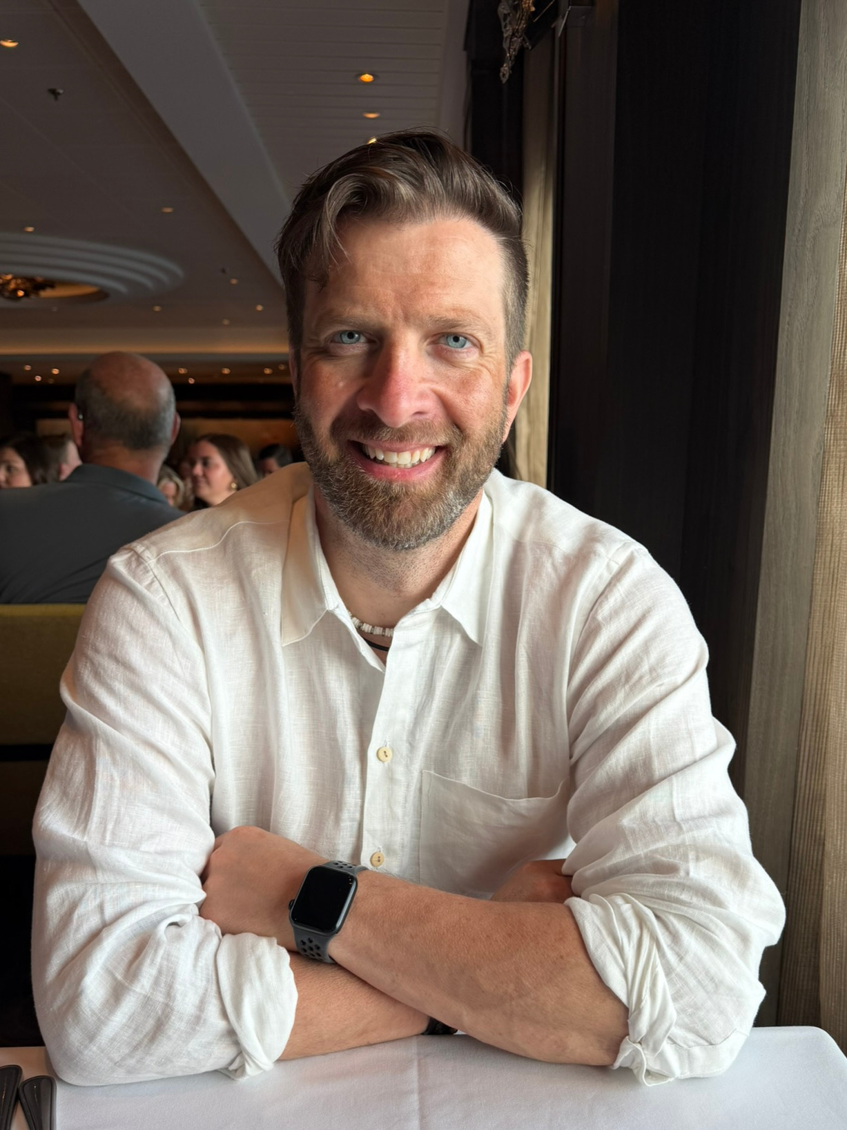 Coach George A. Peterson smiling at a table in a bright setting
